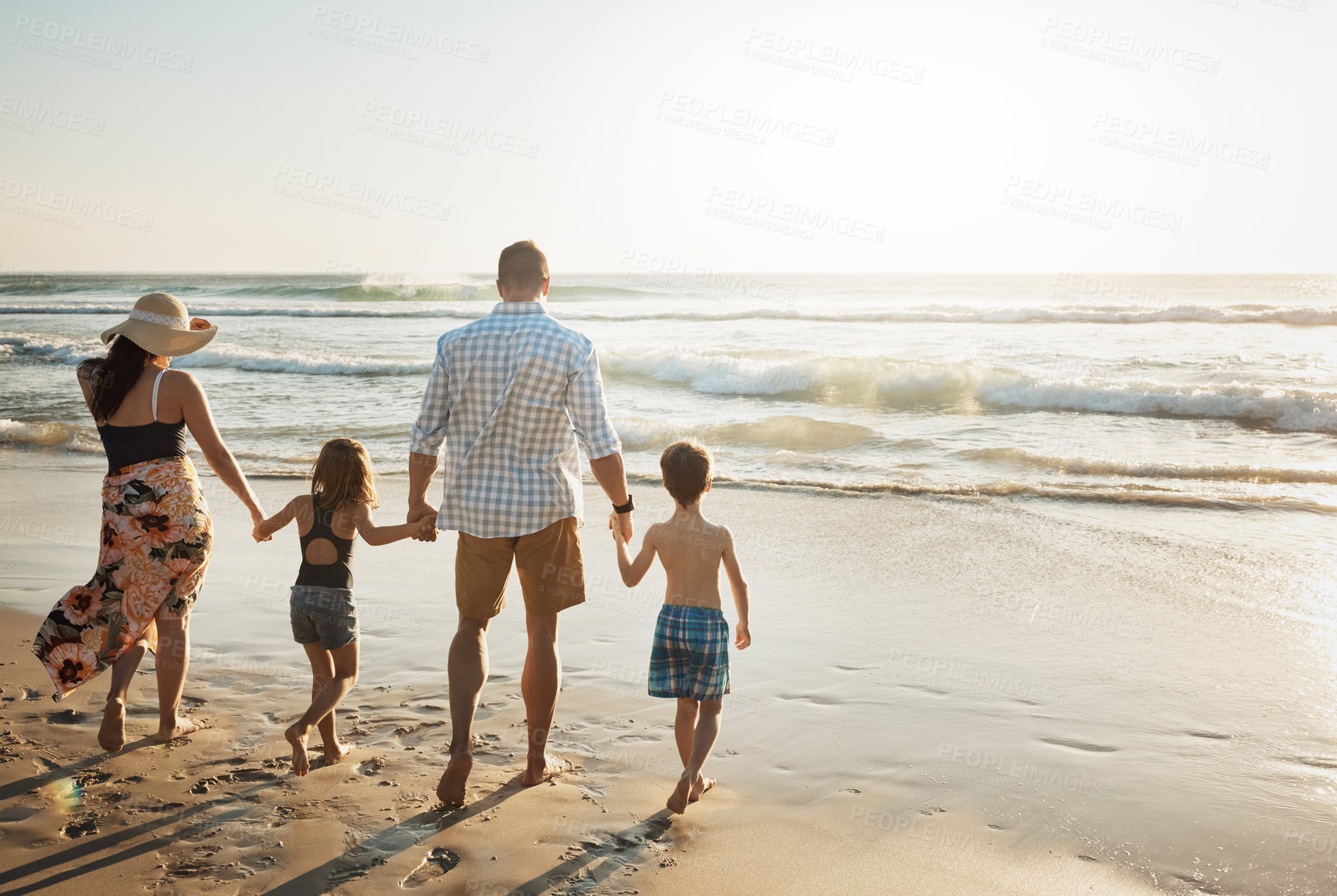 Buy stock photo Beach, walking and holding hands with family for summer holiday, weekend or bonding together in nature. Back view of mother, father and children strolling on ocean coast for outdoor vacation by sea