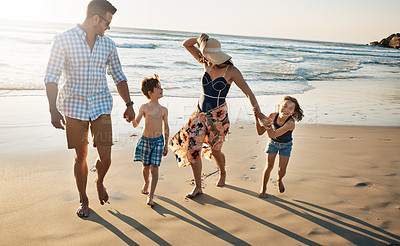 Buy stock photo Happy family, playing and holding hands with kids on beach sunset for summer holiday or bonding together in nature. Mother, father and children with smile for stroll or outdoor weekend by sand shore