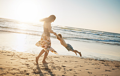 Buy stock photo Shot of a young woman spending the day at the beach with her son