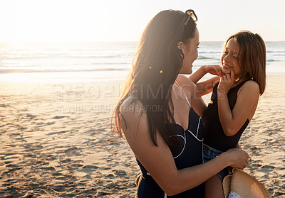 Buy stock photo Shot of a young woman spending the day at the beach with her daughter