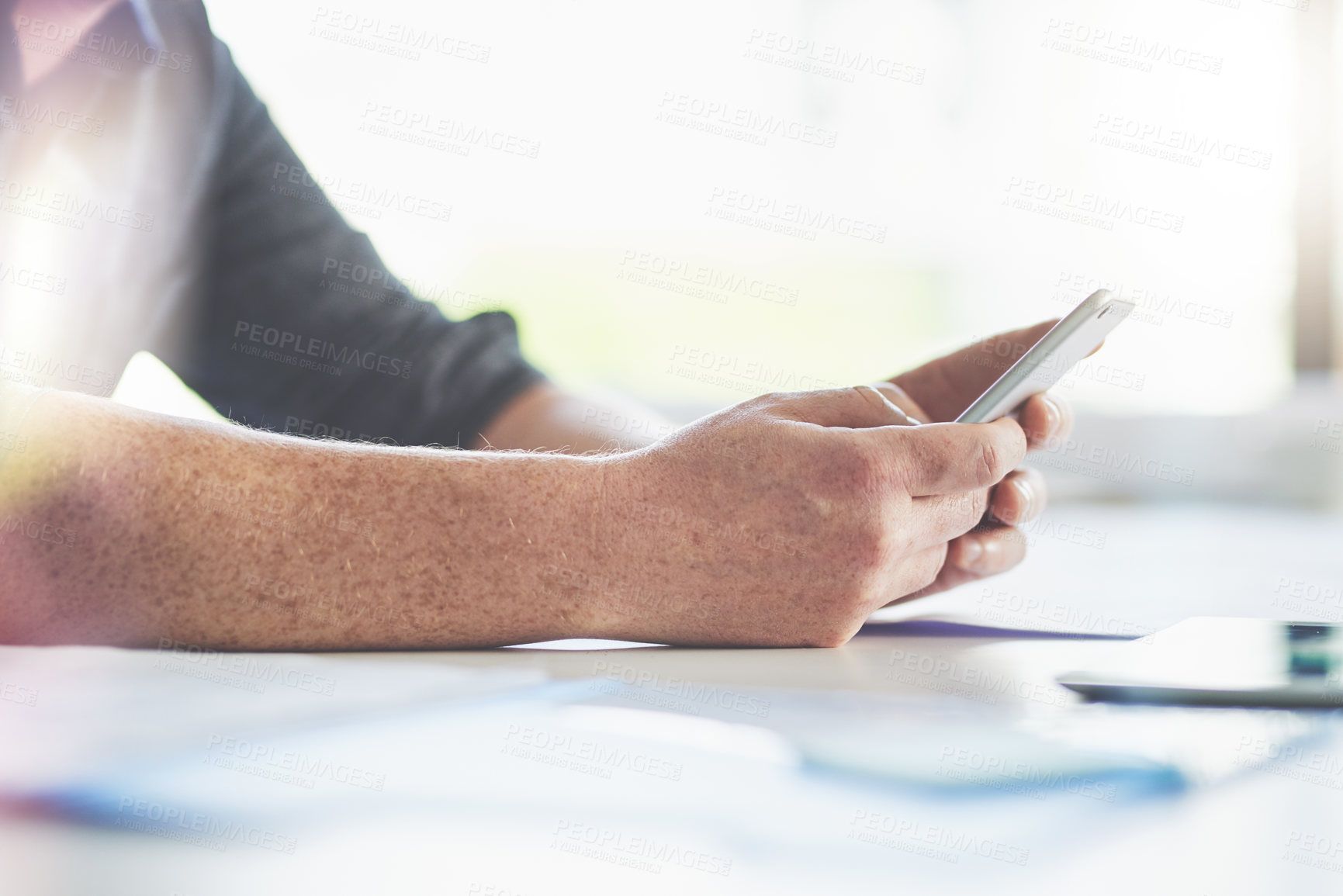 Buy stock photo Closeup shot of an unrecognizable businessman texting on a cellphone in an office