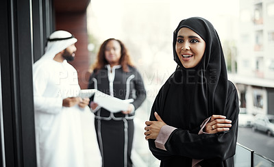 Buy stock photo Cropped shot of an attractive young businesswoman dressed in Islamic traditional clothing standing on her office balcony