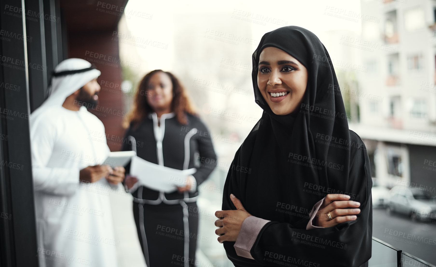 Buy stock photo Cropped shot of an attractive young businesswoman dressed in Islamic traditional clothing standing on her office balcony