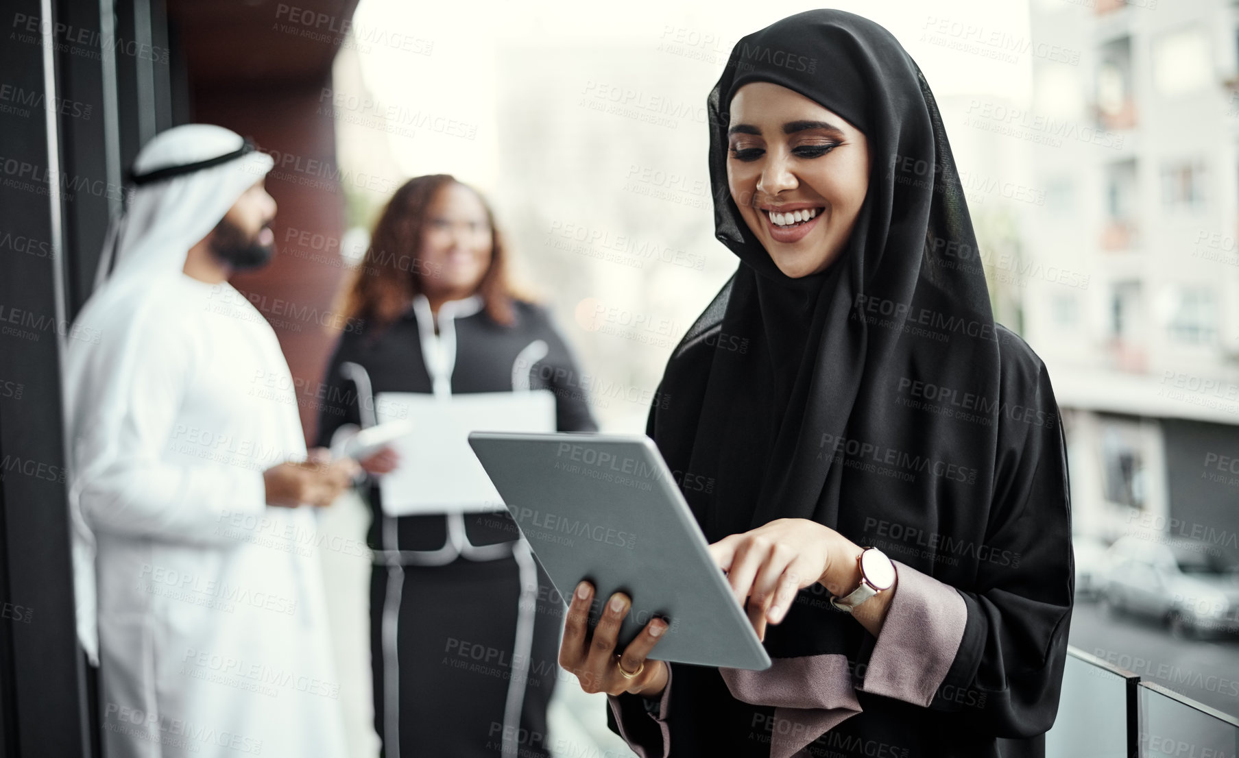 Buy stock photo Cropped shot of an attractive young businesswoman dressed in Islamic traditional clothing using a tablet on her office balcony