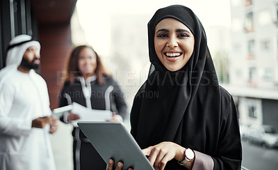 Buy stock photo Cropped portrait of an attractive young businesswoman dressed in Islamic traditional clothing using a tablet on her office balcony