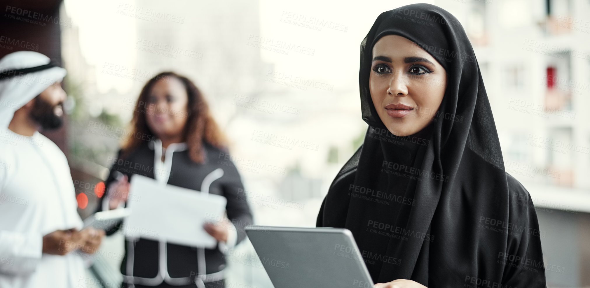 Buy stock photo Cropped shot of an attractive young businesswoman dressed in Islamic traditional clothing using a tablet on her office balcony