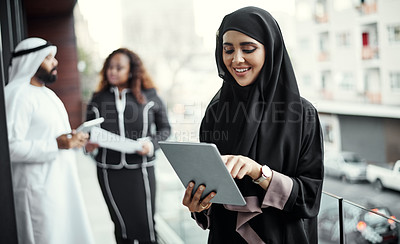 Buy stock photo Cropped shot of an attractive young businesswoman dressed in Islamic traditional clothing using a tablet on her office balcony