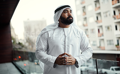 Buy stock photo Cropped shot of a businessman dressed in traditional Islamic clothing working on his office balcony