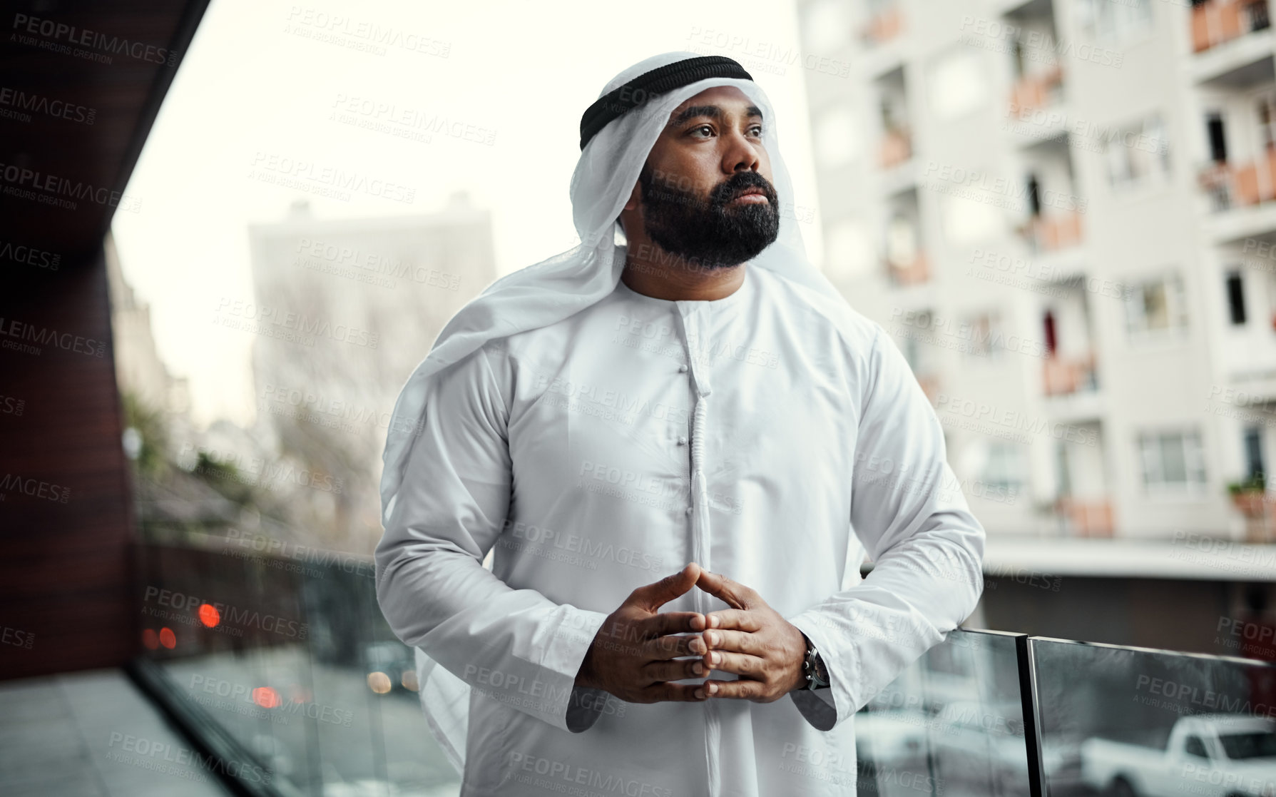 Buy stock photo Cropped shot of a businessman dressed in traditional Islamic clothing working on his office balcony