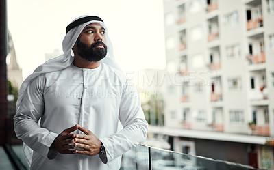 Buy stock photo Cropped shot of a businessman dressed in traditional Islamic clothing working on his office balcony