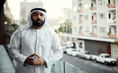 Buy stock photo Cropped portrait of a businessman dressed in traditional Islamic clothing working on his office balcony