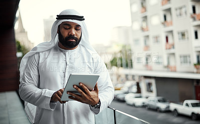 Buy stock photo Cropped shot of a businessman dressed in traditional Islamic clothing working on his office balcony