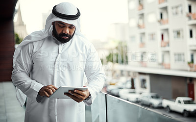 Buy stock photo Cropped shot of a businessman dressed in traditional Islamic clothing working on his office balcony