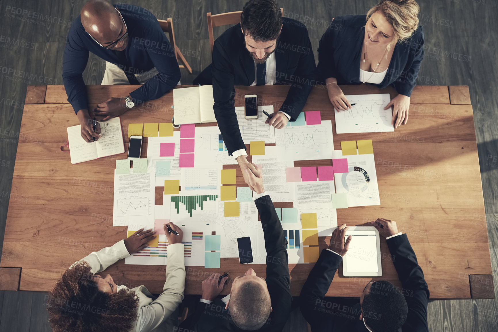 Buy stock photo High angle shot of a team of businesspeople working around a table in the office