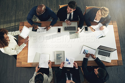 Buy stock photo High angle shot of a team of businesspeople working around a table in the office