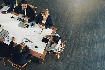 Buy stock photo High angle shot of a team of businesspeople working around a table in the office