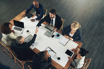 Buy stock photo High angle shot of a team of businesspeople working around a table in the office