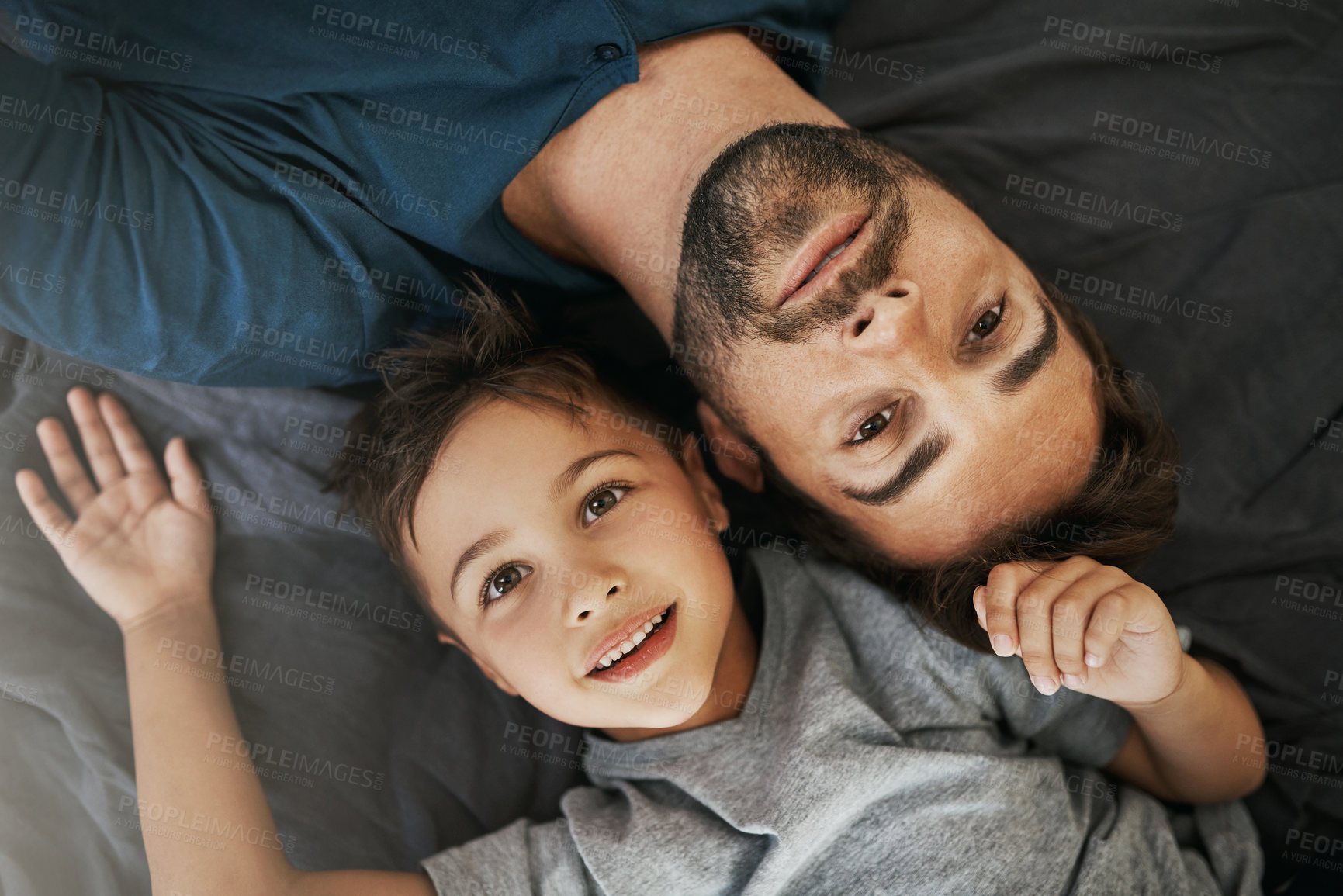 Buy stock photo Father, child and portrait with bed above for holiday, weekend or bonding together at home. Top view, dad and kid, son or little boy lying in bedroom for morning, relax or childhood youth at house