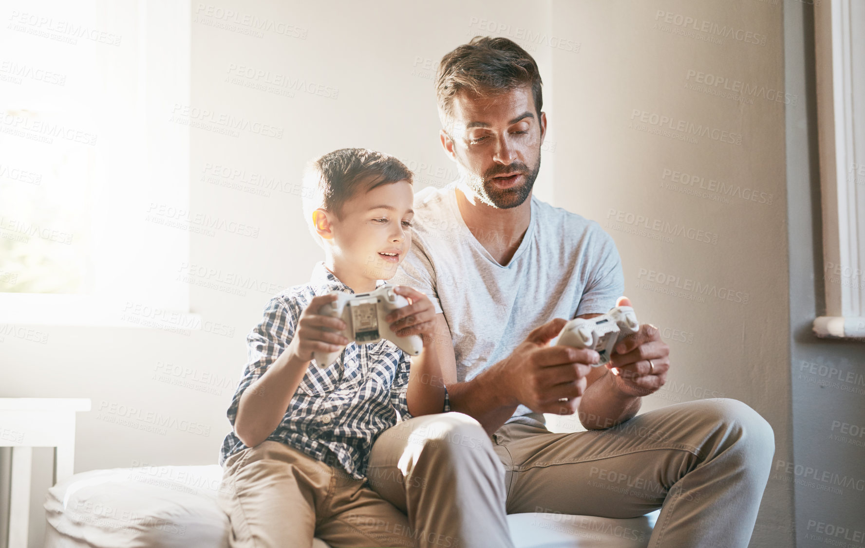 Buy stock photo Cropped shot of a young boy and his father playing video games