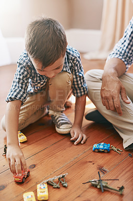 Buy stock photo Shot of a young boy playing with his cars at home