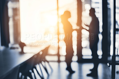Buy stock photo Defocused shot of two businesspeople having a discussion in an office