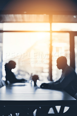 Buy stock photo Defocused shot of two businesspeople working in an office
