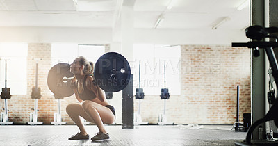 Buy stock photo Full length shot of an attractive young woman lifting weights in the gym