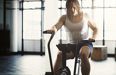 Buy stock photo Fitness, elliptical and man training in gym, workout or exercise for strength, health or wellness. Sports fatigue, tired and exhausted male athlete exercising, cardio or cycling on cross trainer bike