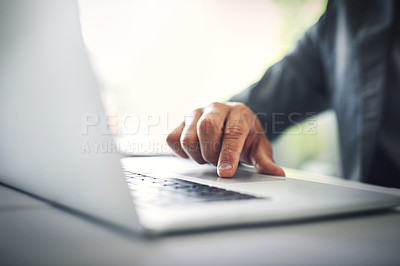 Buy stock photo Shot of an unrecognizable businessman working on his laptop inside of the office during the day