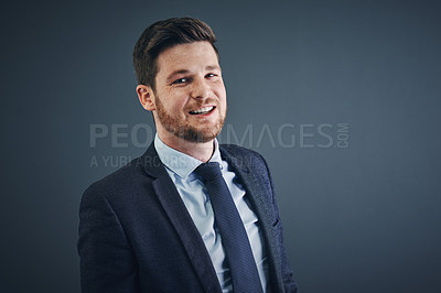 Buy stock photo Studio shot of a cheerful young businessman standing against a dark background