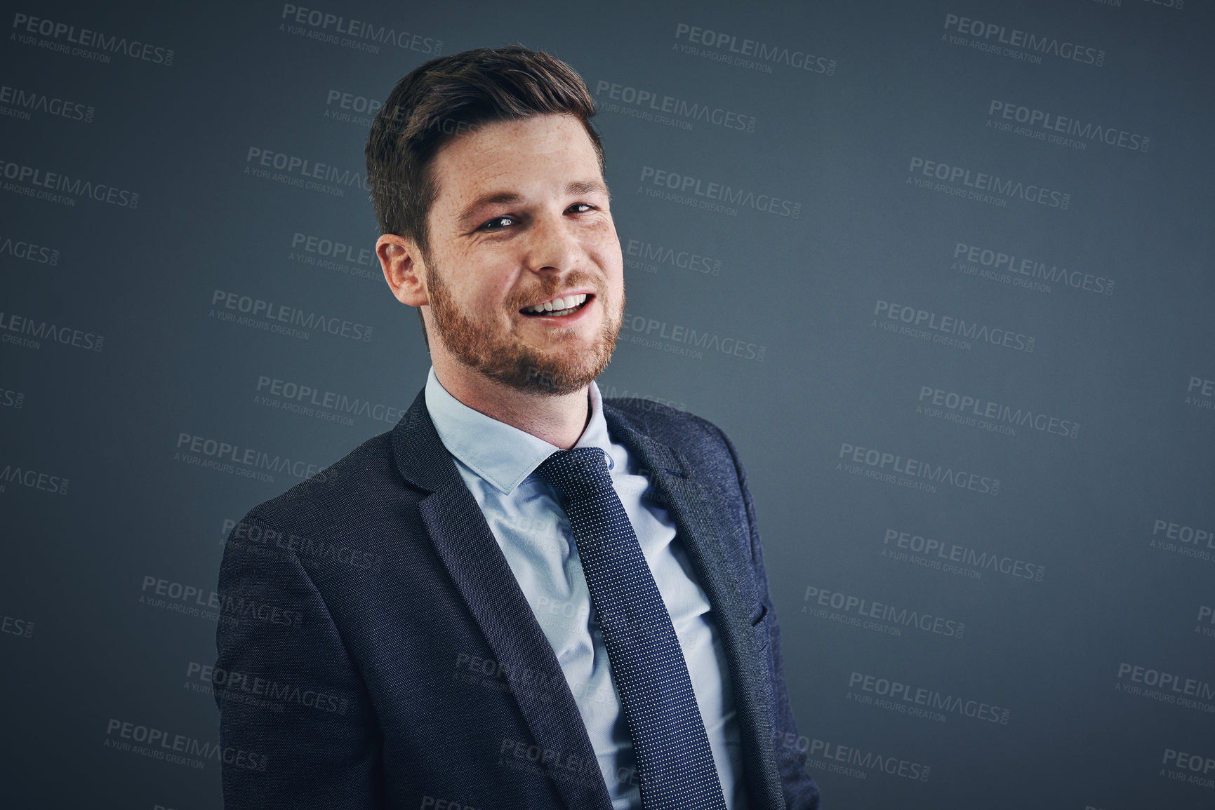 Buy stock photo Studio shot of a cheerful young businessman standing against a dark background