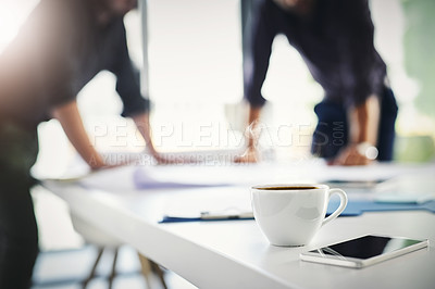 Buy stock photo Shot of two unrecognizable businessmen working through business plans together inside of the office
