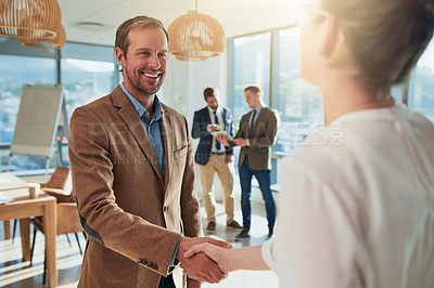 Buy stock photo Cropped shot of two businesspeople shaking hands during a meeting in the boardroom