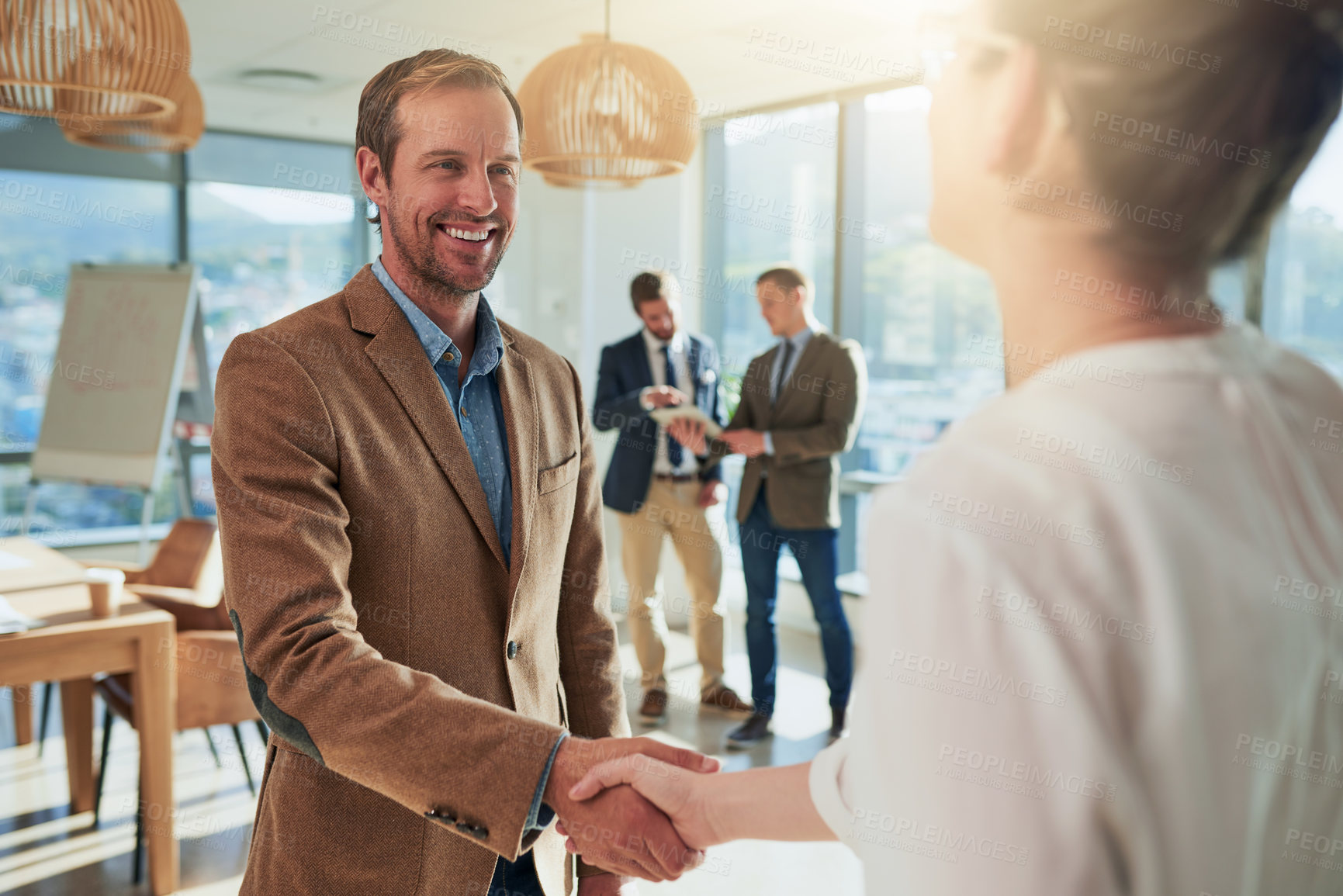 Buy stock photo Cropped shot of two businesspeople shaking hands during a meeting in the boardroom