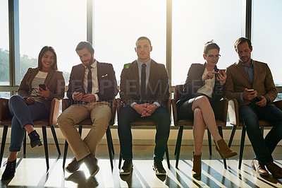 Buy stock photo Full length shot of a group of businesspeople sitting in line while waiting to be interviewed