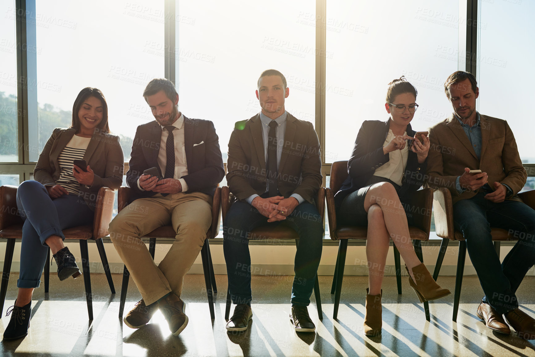 Buy stock photo Full length shot of a group of businesspeople sitting in line while waiting to be interviewed