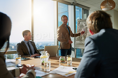 Buy stock photo Cropped shot of a businessman giving a presentation during a meeting in the boardroom