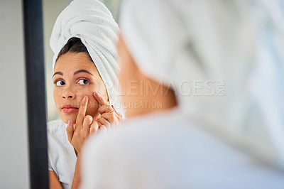 Buy stock photo Shot of an attractive young woman squeezing a pimple on her face in the bathroom