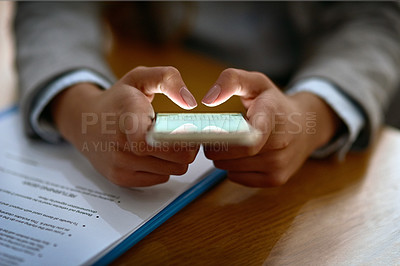 Buy stock photo Cropped shot of a businesswoman using a mobile phone at her desk in a modern office