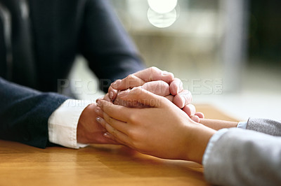 Buy stock photo Cropped shot of a businessman and businesswoman compassionately holding hands at a table
