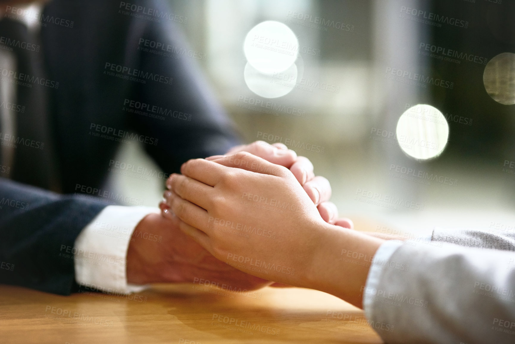 Buy stock photo People, holding hands and closeup in office for support, empathy and grief counseling in HR. Solidarity, partners and gesture at table for compassion, understanding and trust in business for help 