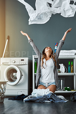 Buy stock photo Shot of a young attractive woman throwing her laundry in the air at home