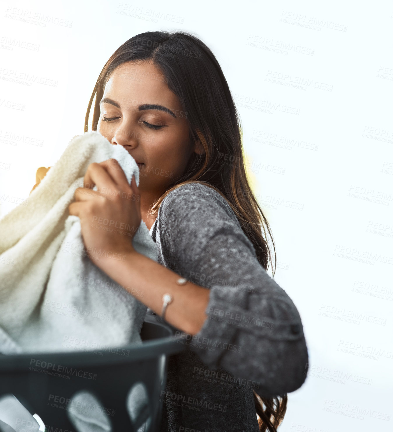 Buy stock photo Shot of a young attractive woman doing her laundry at home