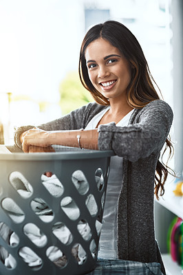 Buy stock photo Shot of a young attractive woman doing her laundry at home