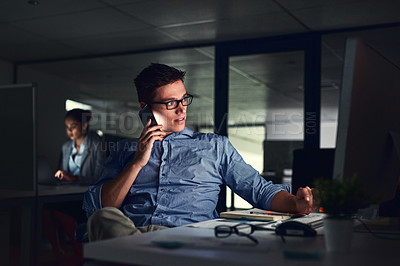 Buy stock photo Shot of a young businessman working late at night in a modern office