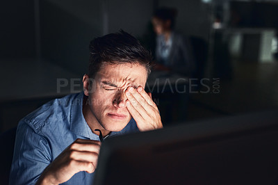 Buy stock photo Shot of a young businessman working late at night in a modern office