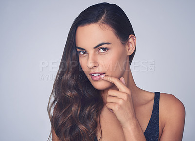 Buy stock photo Studio shot of a beautiful young woman posing against a purple background