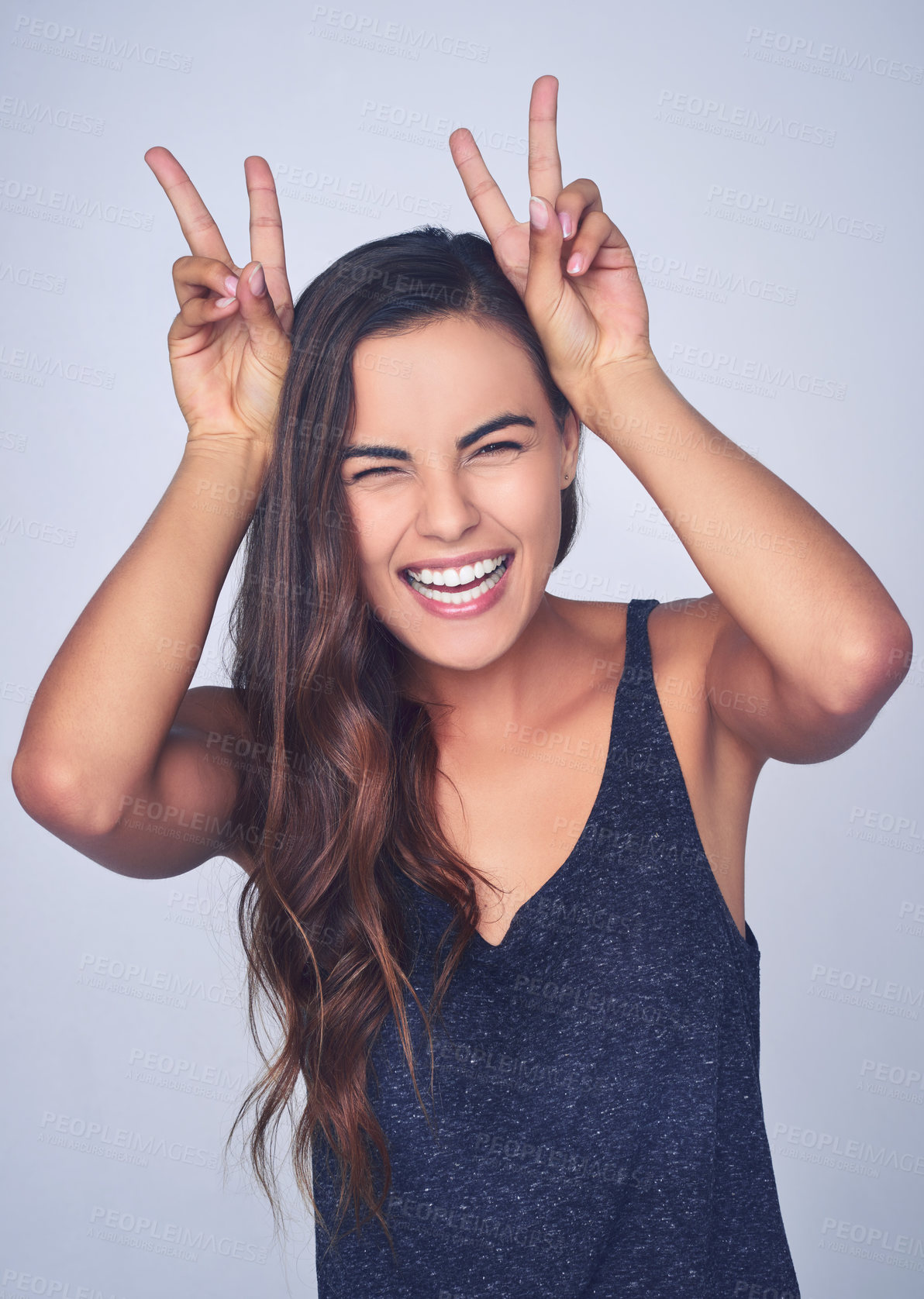 Buy stock photo Playful, woman and portrait with peace sign in studio for silly, comedy and fun personality. Happy, laughing and female person with bunny ears emoji for goofy, humor and joking by white background