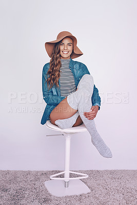 Buy stock photo Fashion, happy and portrait of woman on stool in studio with stylish, trendy and casual outfit for confidence. Smile, chair and female person from Canada with hat and chic clothes by white background