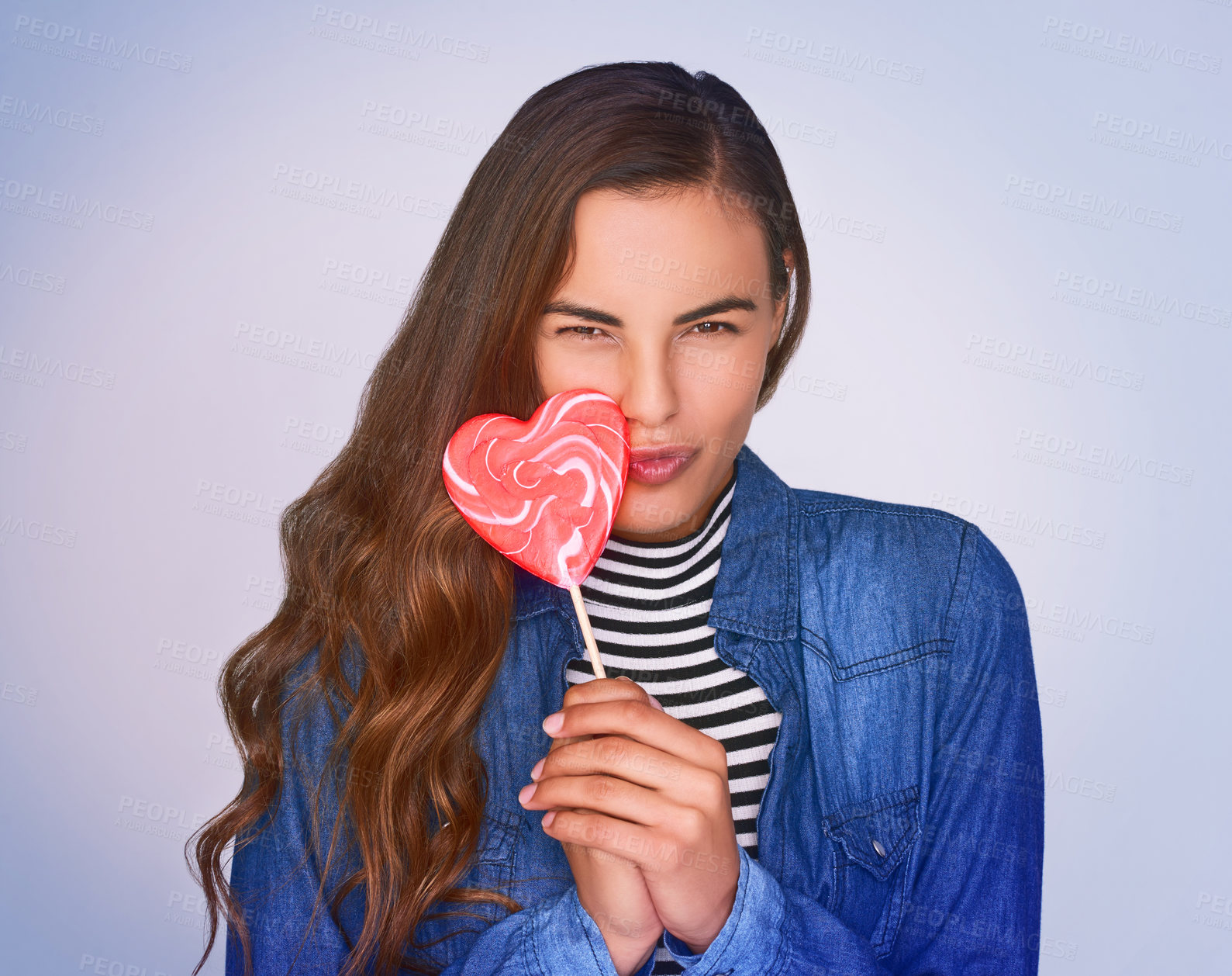 Buy stock photo Heart, lollipop and pout with portrait of woman in studio on blue background for flirt, love or valentines day. Face, fashion and sweets with confident person in denim jacket for dating or romance